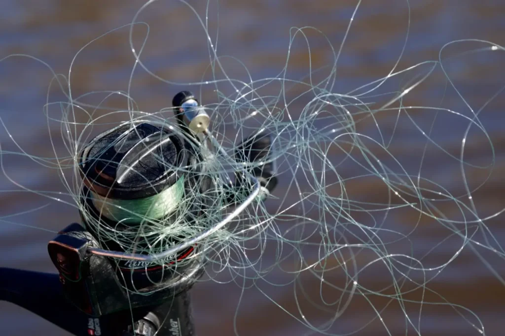 Fisherman trying to untangle fishing line tangles