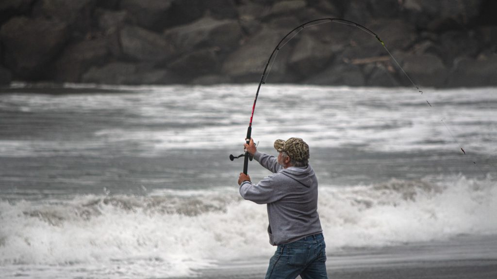 rod being cast on a beach