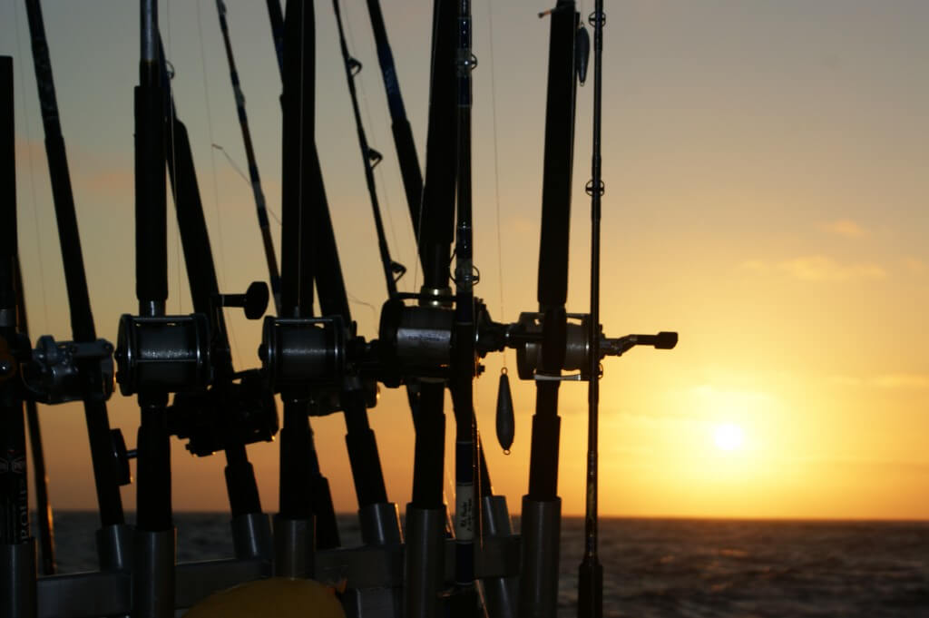 trolling fishing reels during a sunset on the ocean